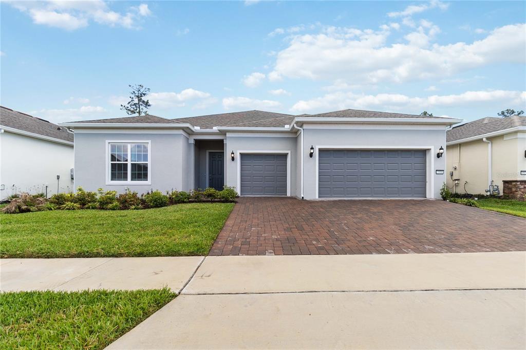 A single-story house with a gray exterior, a three-car garage, and a brick paver driveway — 2531 PINE PRESERVE COURT, ST CLOUD, FL