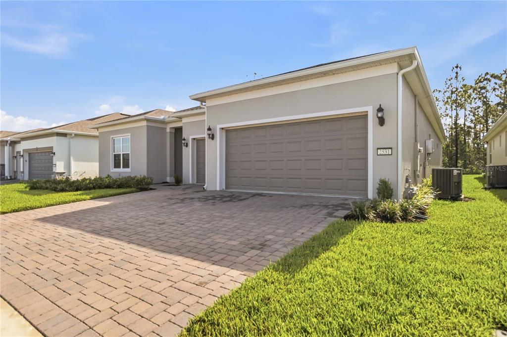 A single-story house with a beige exterior, a two-car garage, and a paved driveway — 2531 PINE PRESERVE COURT, ST CLOUD, FL