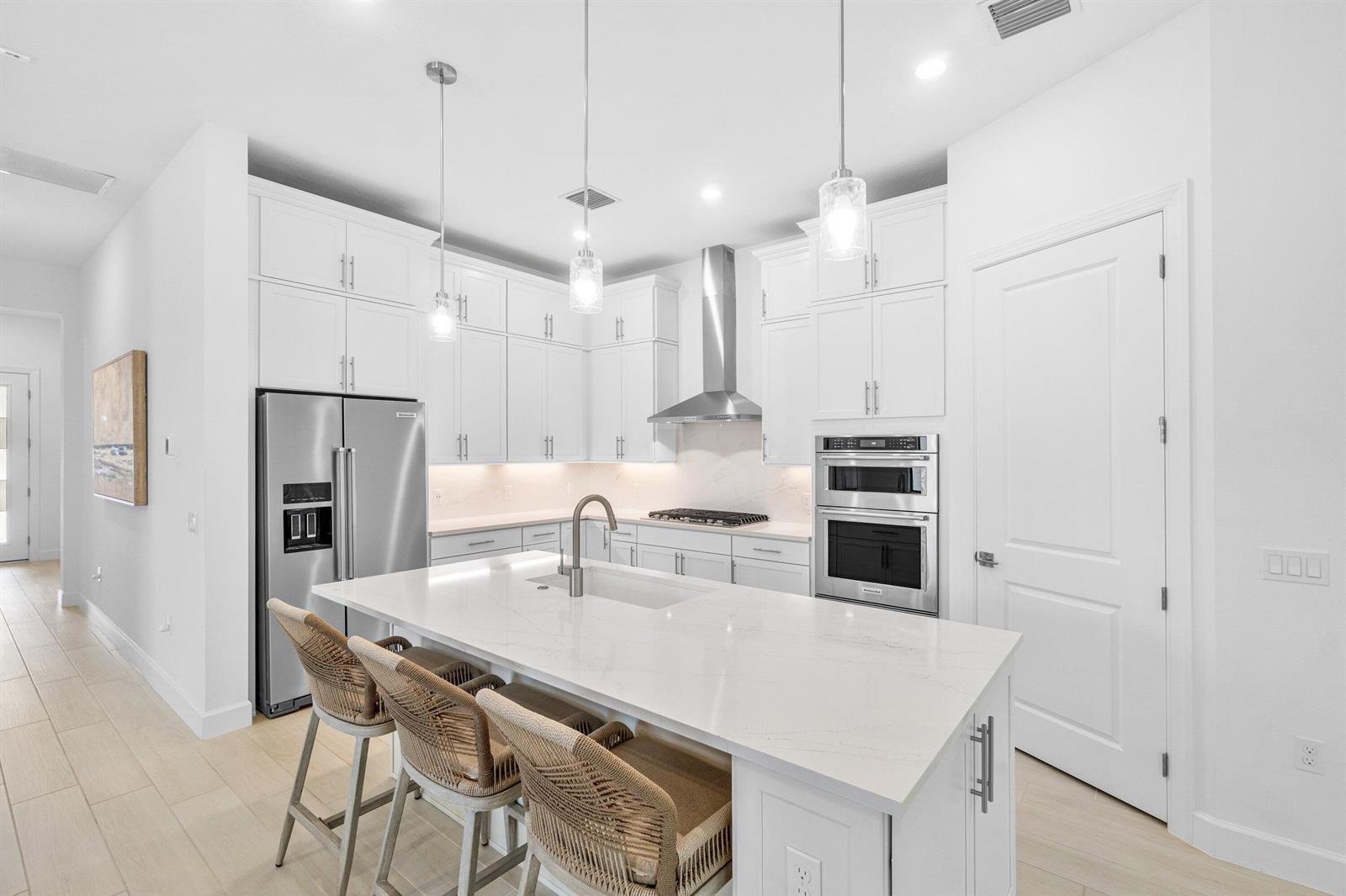 A bright open-concept living and dining area features a large sectional sofa and modern kitchen — 9303 Cape Honey Bee Lane, Lake Worth FL 33467, LAKE WORTH, FL