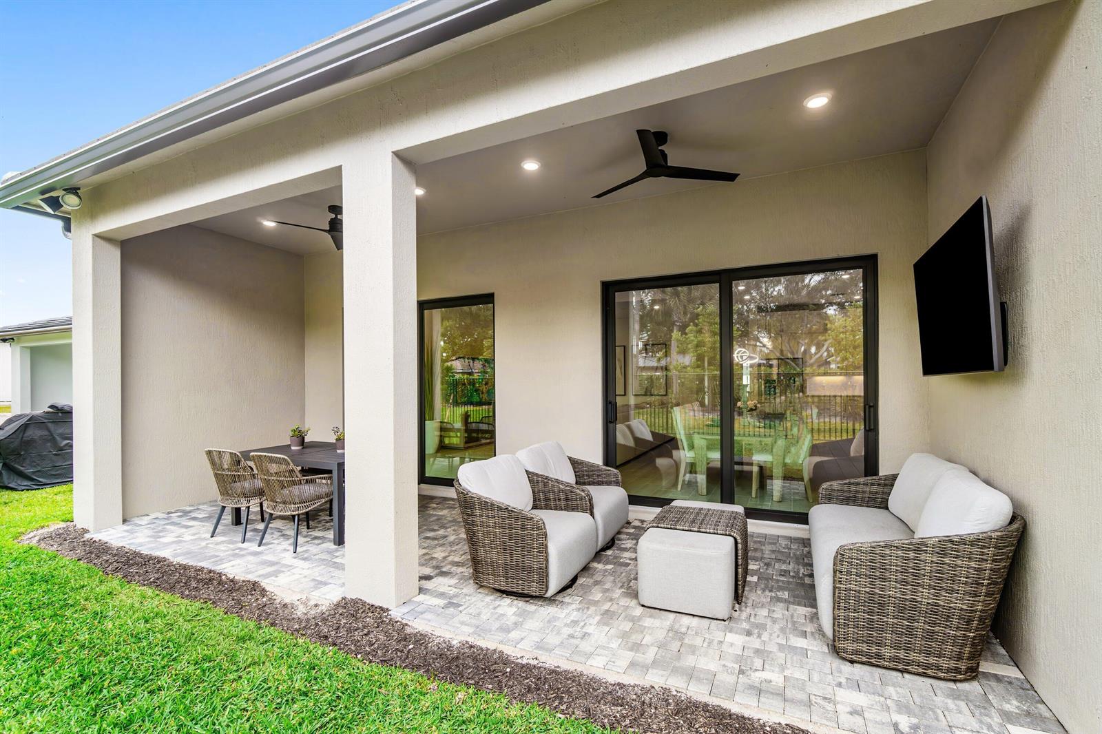 A modern white kitchen features a large quartz island, stainless steel appliances, and woven stools — 9303 Cape Honey Bee Lane, Lake Worth FL 33467, LAKE WORTH, FL