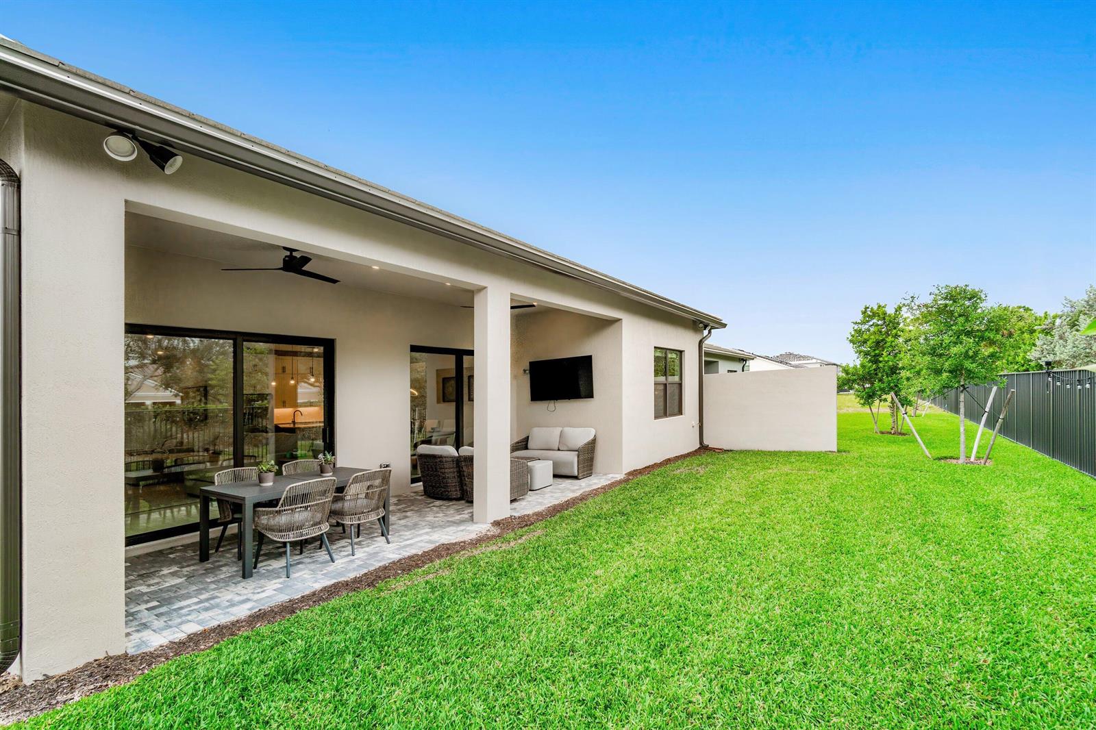 A modern kitchen features white cabinetry, stainless steel appliances, and light-colored countertops — 9303 Cape Honey Bee Lane, Lake Worth FL 33467, LAKE WORTH, FL