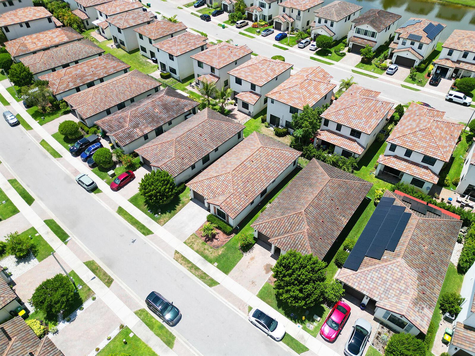 An aerial view shows a suburban neighborhood with rows of houses featuring tiled roofs — 5542 Useppa Drive, Ave Maria FL 34142, AVE MARIA, FL