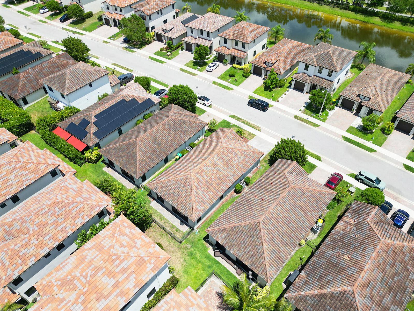 An aerial view shows a suburban neighborhood with houses featuring tiled roofs and driveways — 5542 Useppa Drive, Ave Maria FL 34142, AVE MARIA, FL