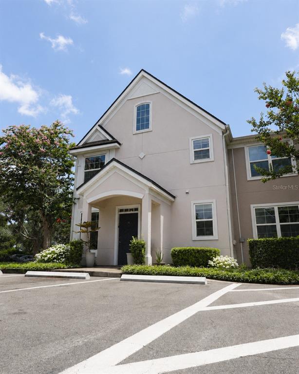 A two-story building with a light-colored stucco exterior and a covered entryway — 3213 GREENWICH VILLAGE BOULEVARD UNIT 102, ORLANDO, FL