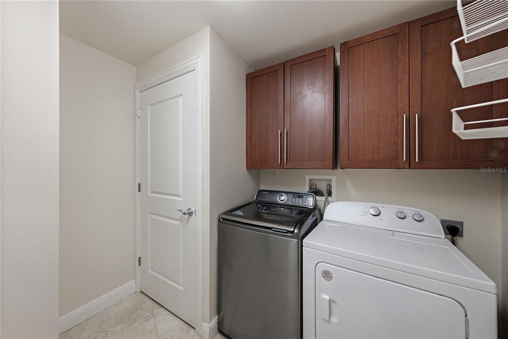 A hallway features an elevator, a plain door, and a door labeled 1103 — 450 KNIGHTS RUN AVENUE UNIT 1103, TAMPA, FL