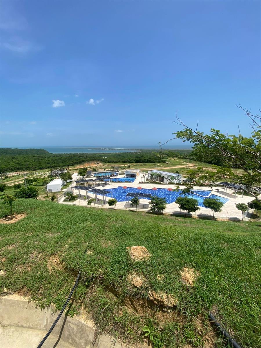 An elevated view of a swimming pool complex surrounded by green hills and the ocean — 90 90A, Tubará, Atlántico, Colombia, FL, FL