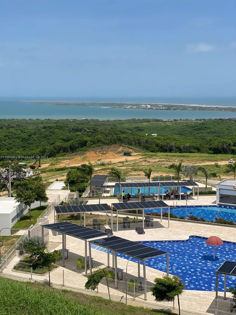 An elevated view shows a swimming pool complex with shaded seating areas overlooking a coastal landscape — 90 90A, Tubará, Atlántico, Colombia, FL, FL