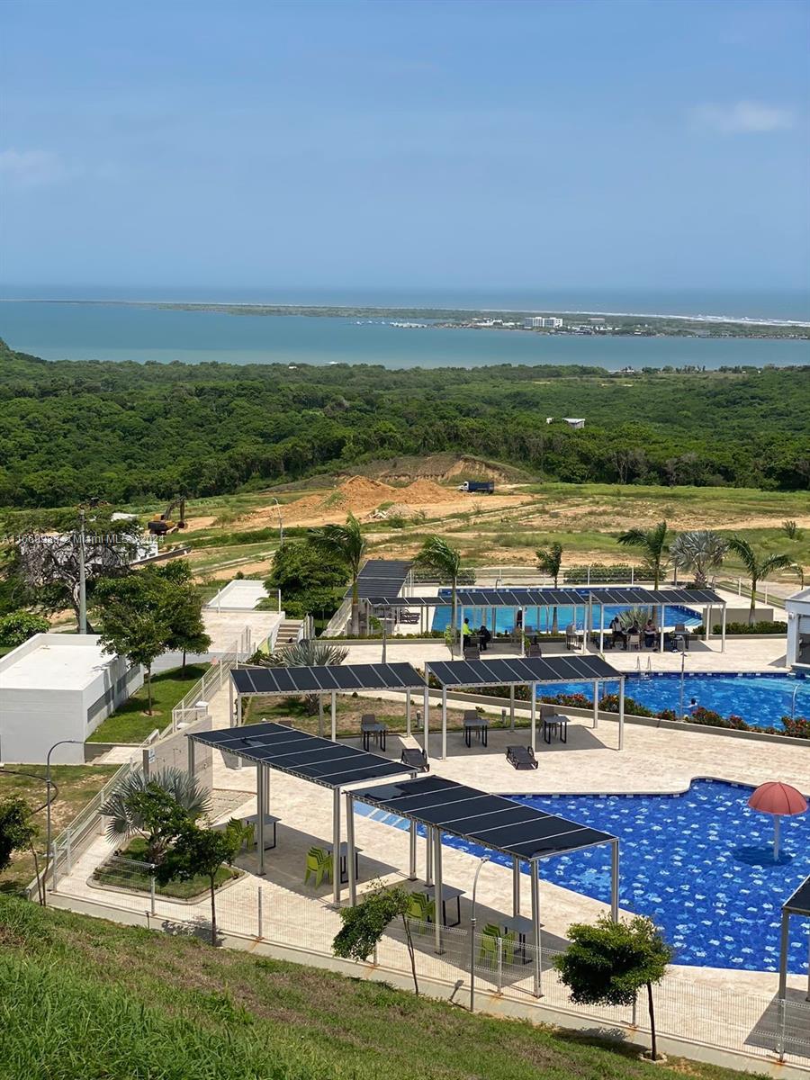 An elevated view of a swimming pool complex with shaded seating areas overlooking a coastal landscape — 90 90A, Tubará, Atlántico, Colombia, FL, FL