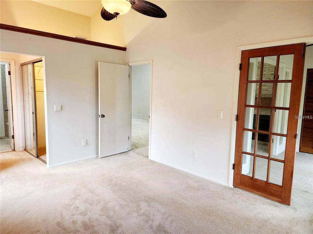 A carpeted room features a vaulted ceiling, a ceiling fan, and a wooden French door — 4356 MIDDLEBROOK ROAD UNIT 3, ORLANDO, FL