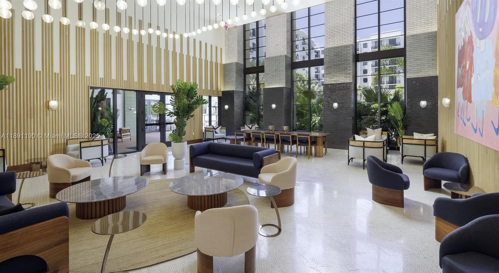 A modern, high-ceilinged lobby features contemporary furniture, large windows, and a decorative light installation — 11200 Biscayne Blvd # B2, Miami FL 33181, MIAMI, FL