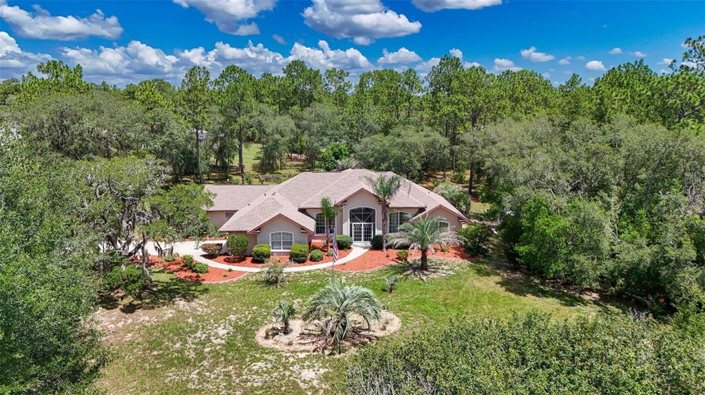 An aerial view of a single-story house surrounded by trees with a landscaped front yard — 4921 N CHEYENNE DRIVE, BEVERLY HILLS, FL