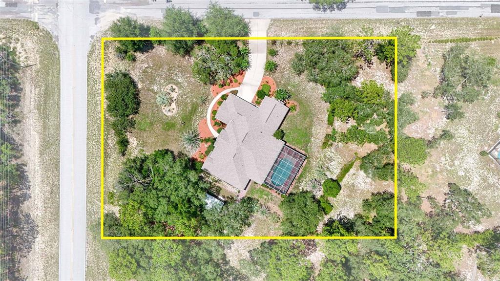 An aerial view shows a house with a pool and driveway on a wooded lot — 4921 N CHEYENNE DRIVE, BEVERLY HILLS, FL