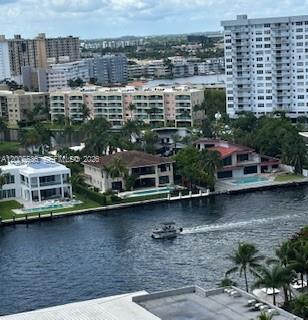 An aerial view shows a canal with a boat passing several waterfront homes and buildings — 1985 S Ocean Dr # 21P, Hallandale Beach FL 33009, HALLANDALE BEACH, FL