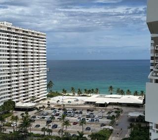 An elevated view of a large apartment building, a parking lot, and the ocean beyond — 1985 S Ocean Dr # 21P, Hallandale Beach FL 33009, HALLANDALE BEACH, FL