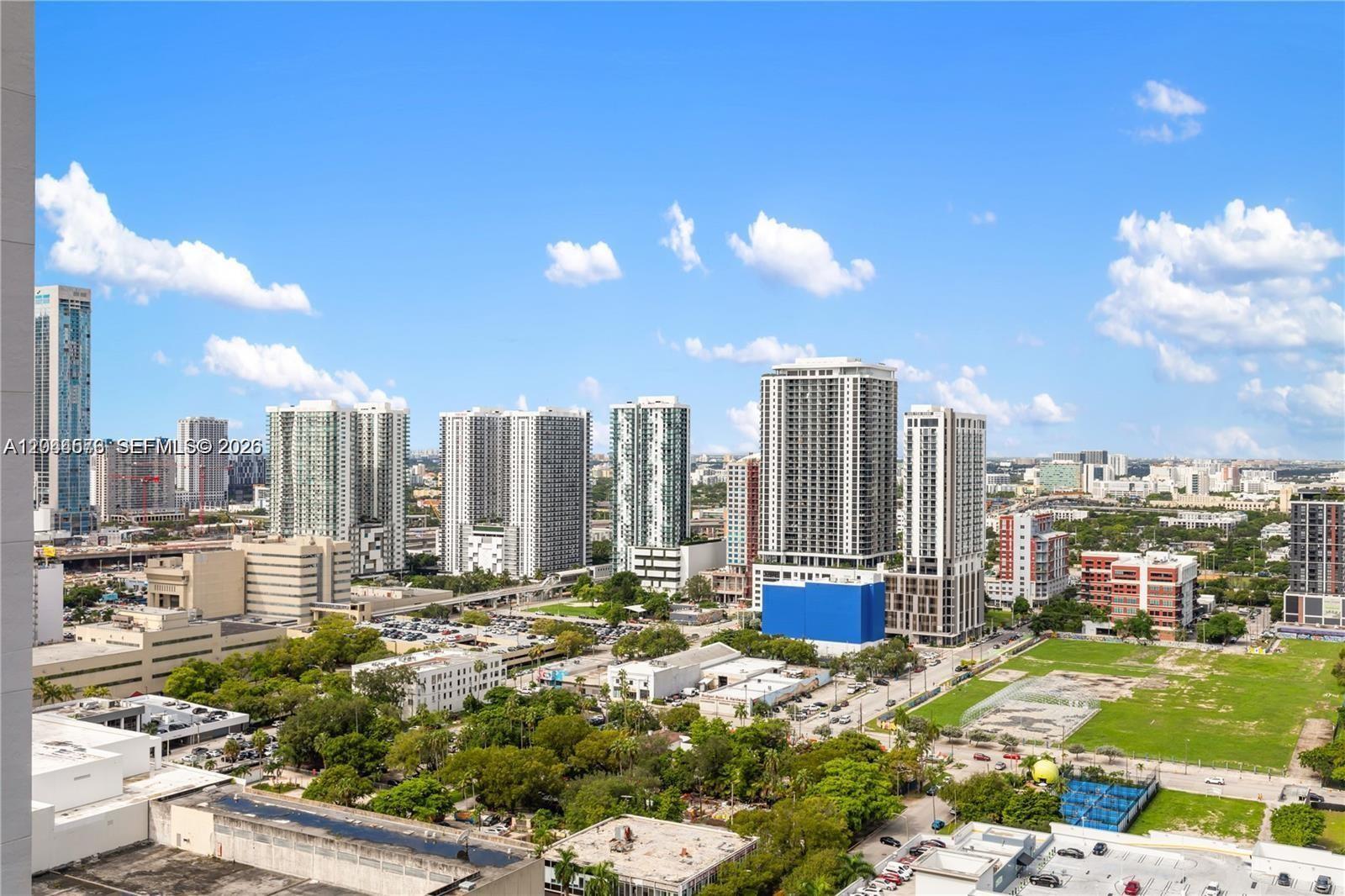 An elevated view shows a cityscape with multiple high-rise buildings, parking lots, and green spaces — 488 NE 18th St # 2802, Miami FL 33132, MIAMI, FL