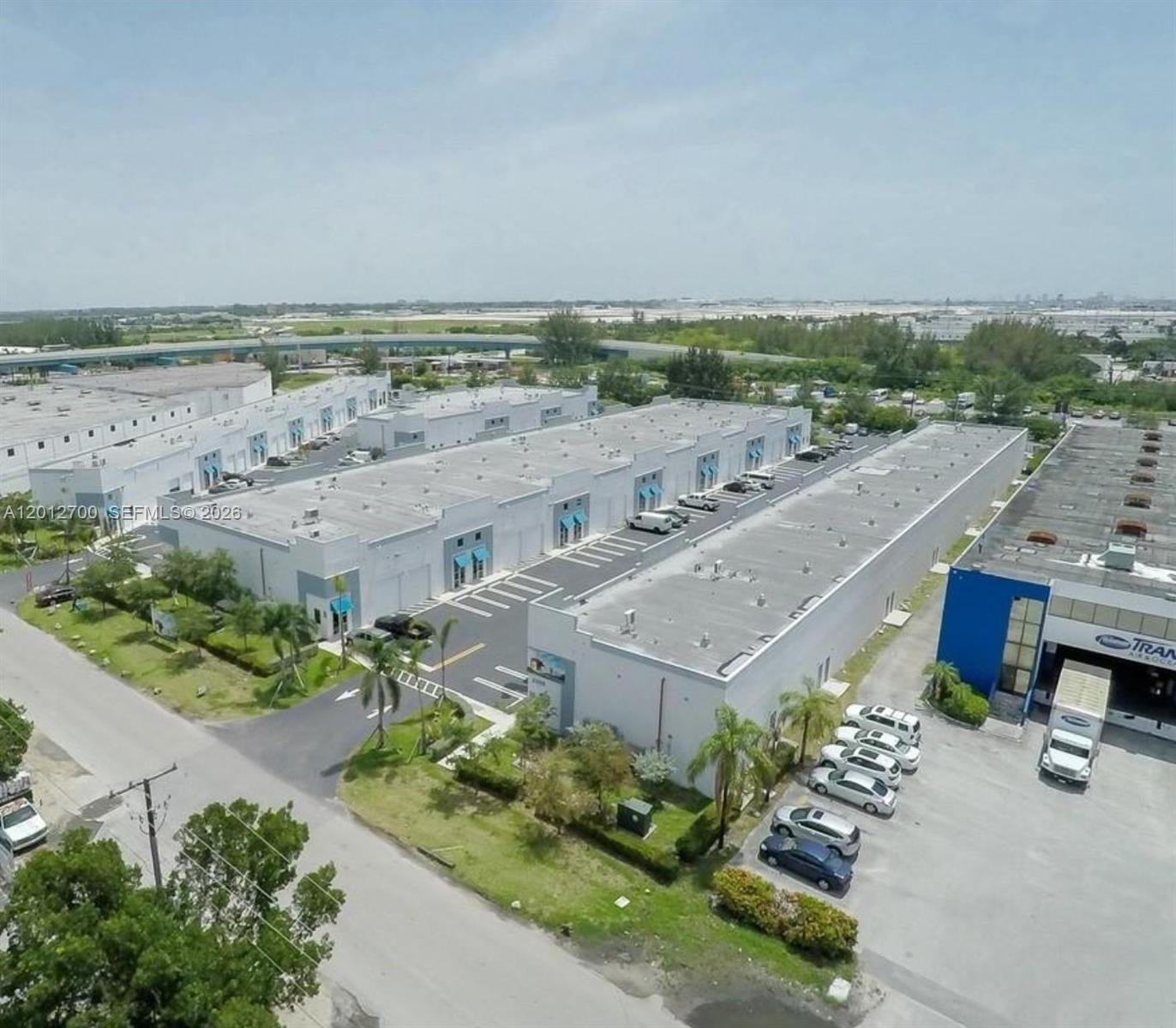 An aerial view shows a commercial warehouse complex with parking lots and surrounding greenery — 2355 NW 70th Ave 11, Miami FL 33122, MIAMI, FL