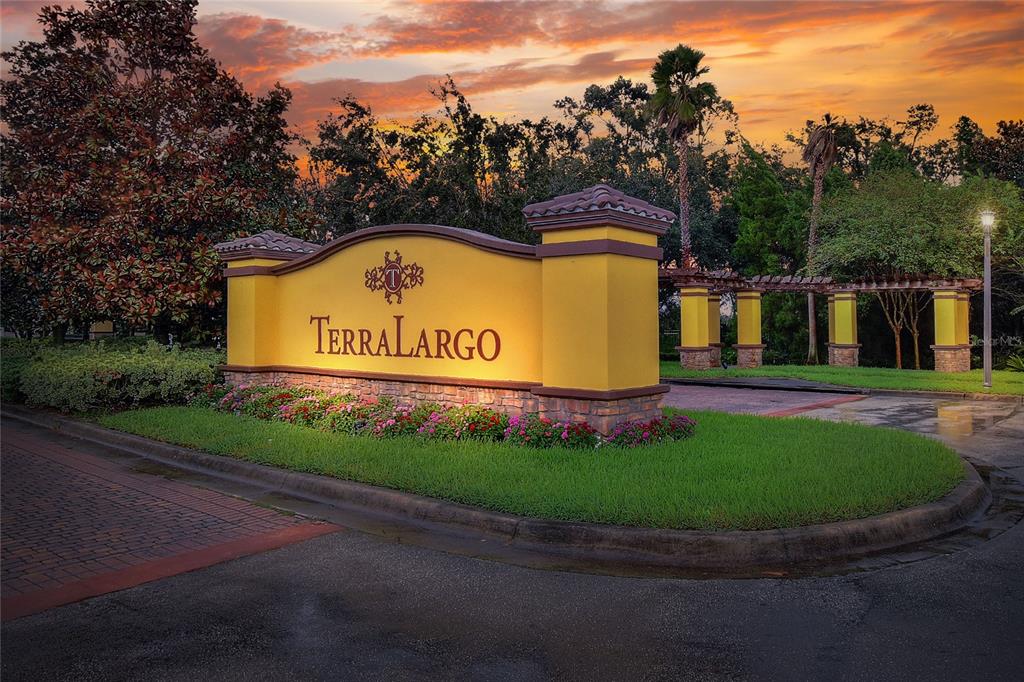 A yellow monument sign for the TerraLargo community stands in front of a landscaped entrance — 3935 SUNSET LAKE DRIVE, LAKELAND, FL