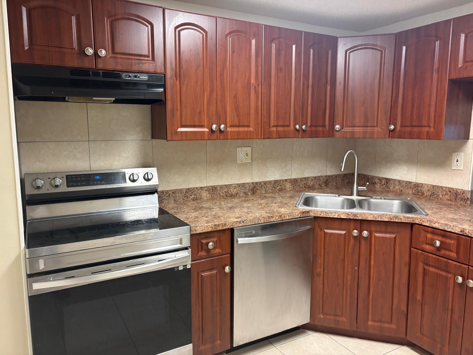 A kitchen with cherry wood cabinets, stainless steel appliances, and brown laminate countertops — 1700 NW 58th Terrace # 1b, Sunrise FL 33313, SUNRISE, FL