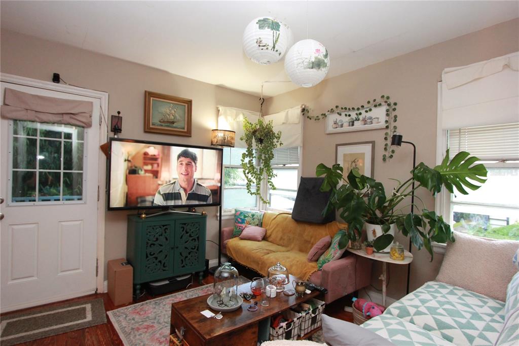A living room features a television, a yellow sofa, a coffee table, and hanging lanterns — 415 E GORE STREET, ORLANDO, FL