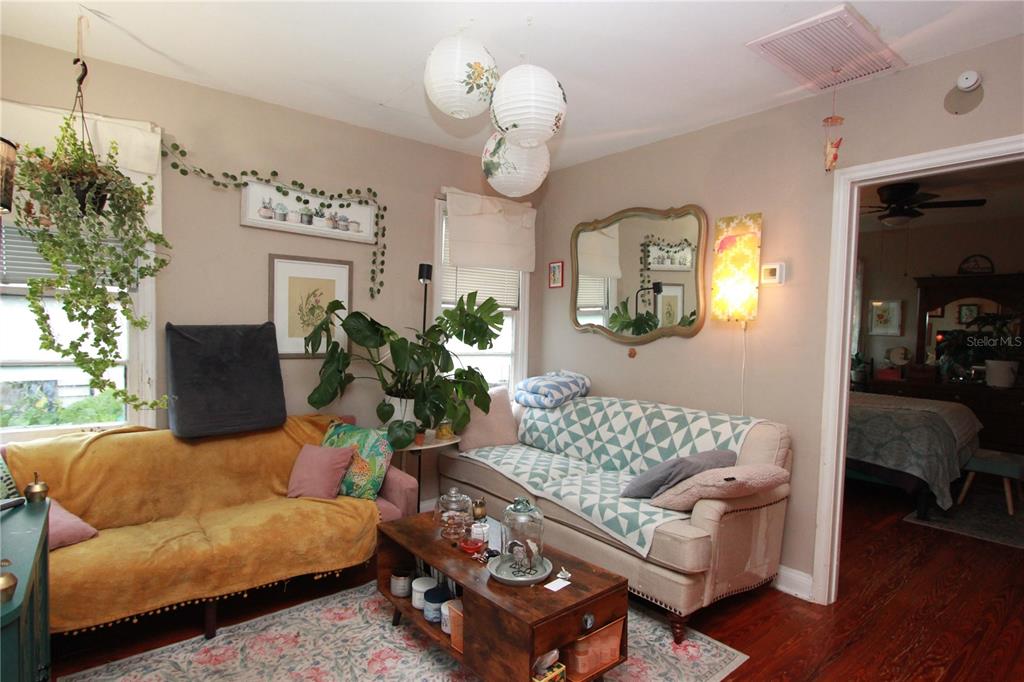 A living room features two sofas, a coffee table, hanging paper lanterns, and indoor plants — 415 E GORE STREET, ORLANDO, FL