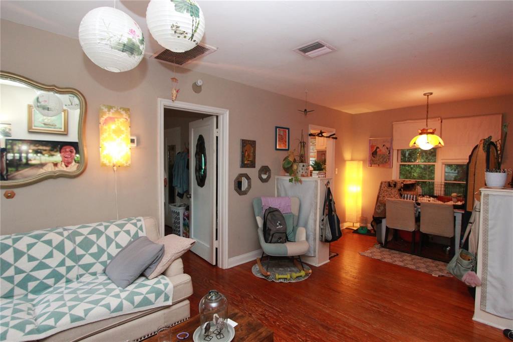 A living room with a patterned sofa, hardwood floors, a rocking chair, and paper lanterns — 415 E GORE STREET, ORLANDO, FL