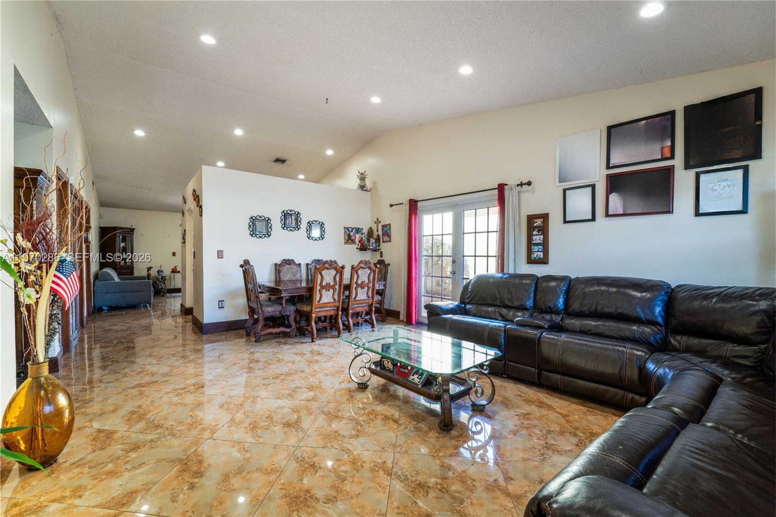 A living and dining area features glossy brown tile floors, a leather sectional, and glass table — 14526 SW 106th Ter, Miami FL 33186, MIAMI, FL