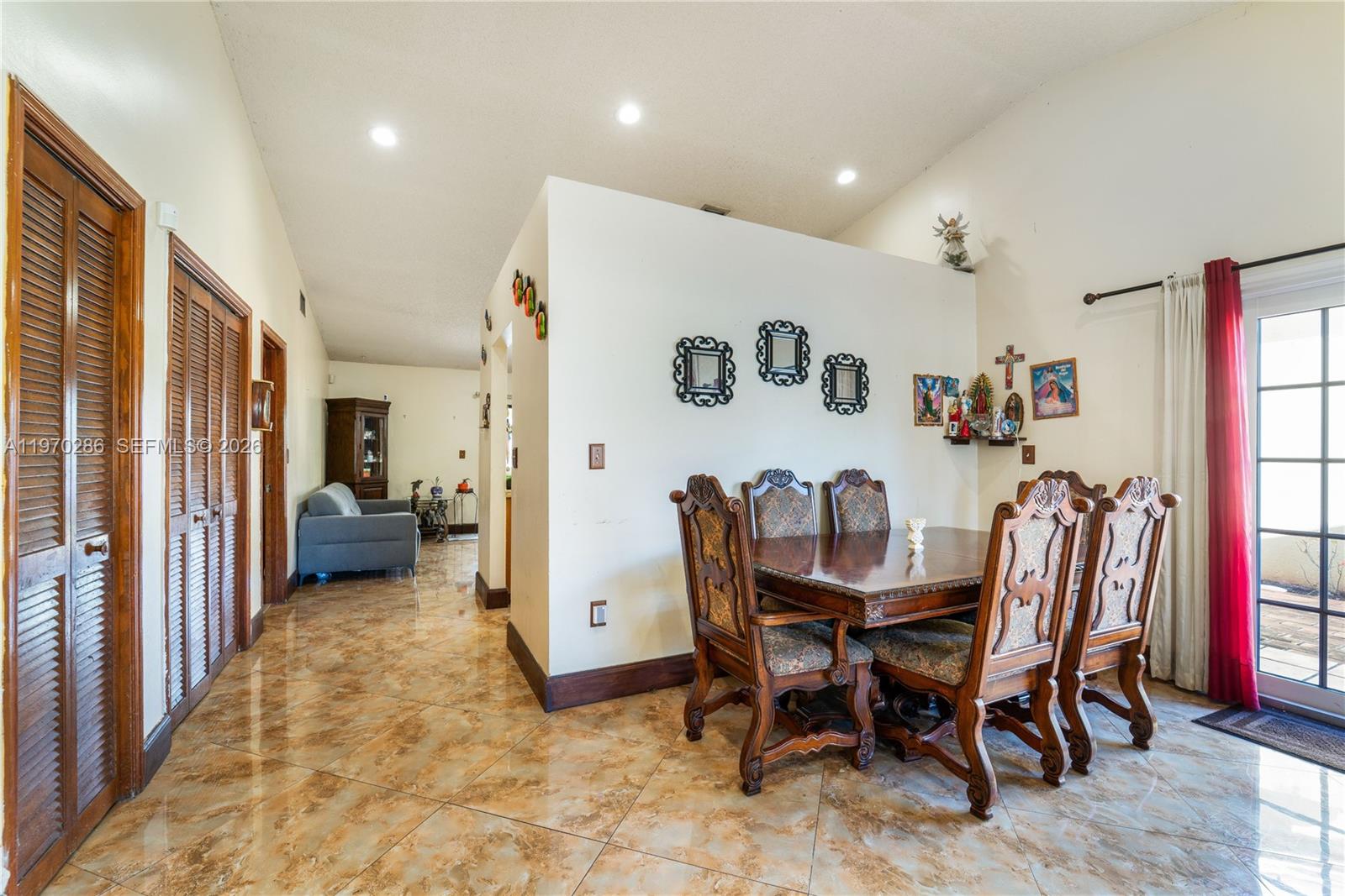 A dining area with a wooden table and chairs sits on tiled floors near a hallway — 14526 SW 106th Ter, Miami FL 33186, MIAMI, FL