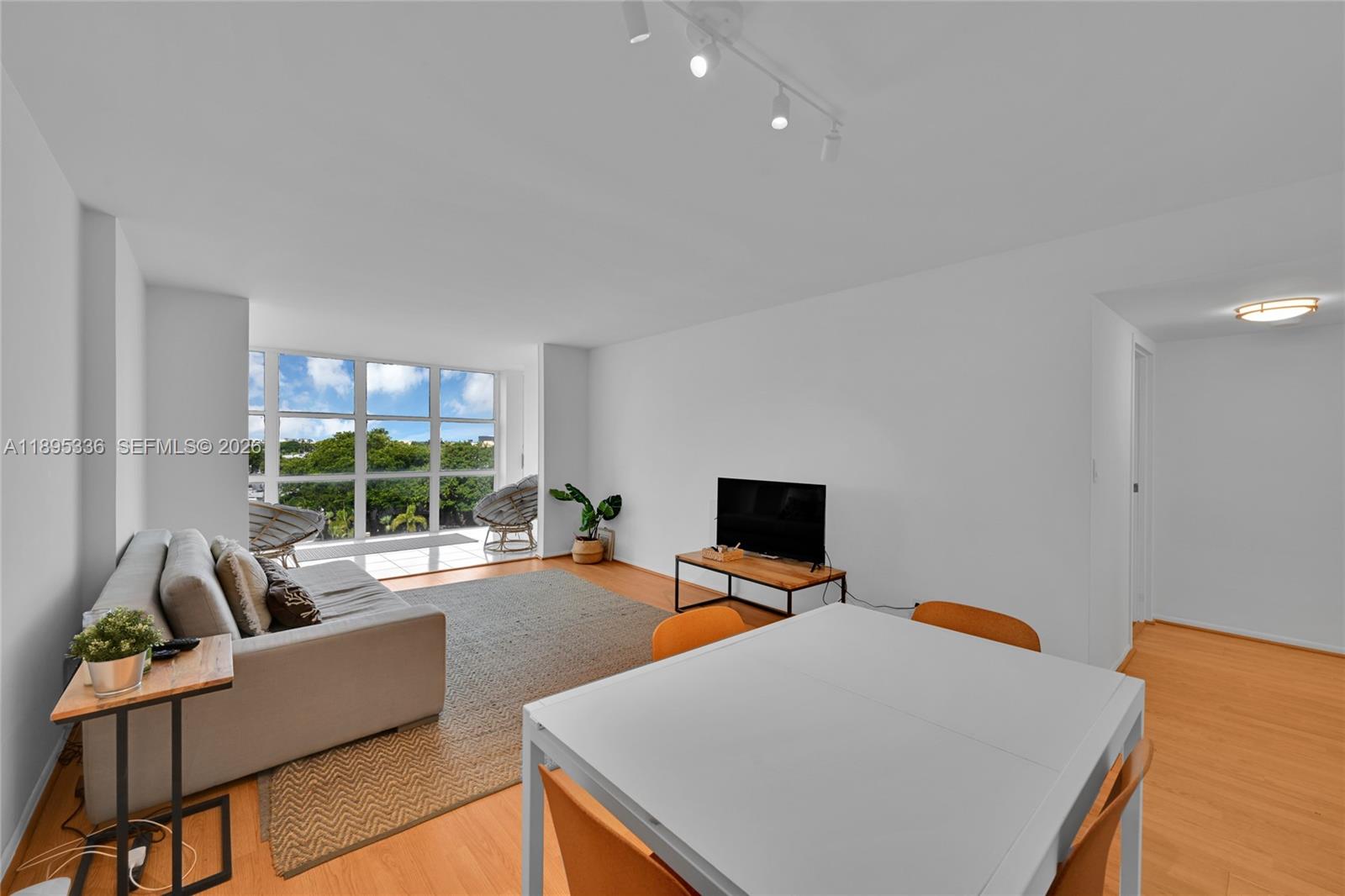 A living and dining area features light wood floors, white walls, and floor-to-ceiling windows — 800 Parkview Dr # 605, Hallandale Beach FL 33009, HALLANDALE BEACH, FL