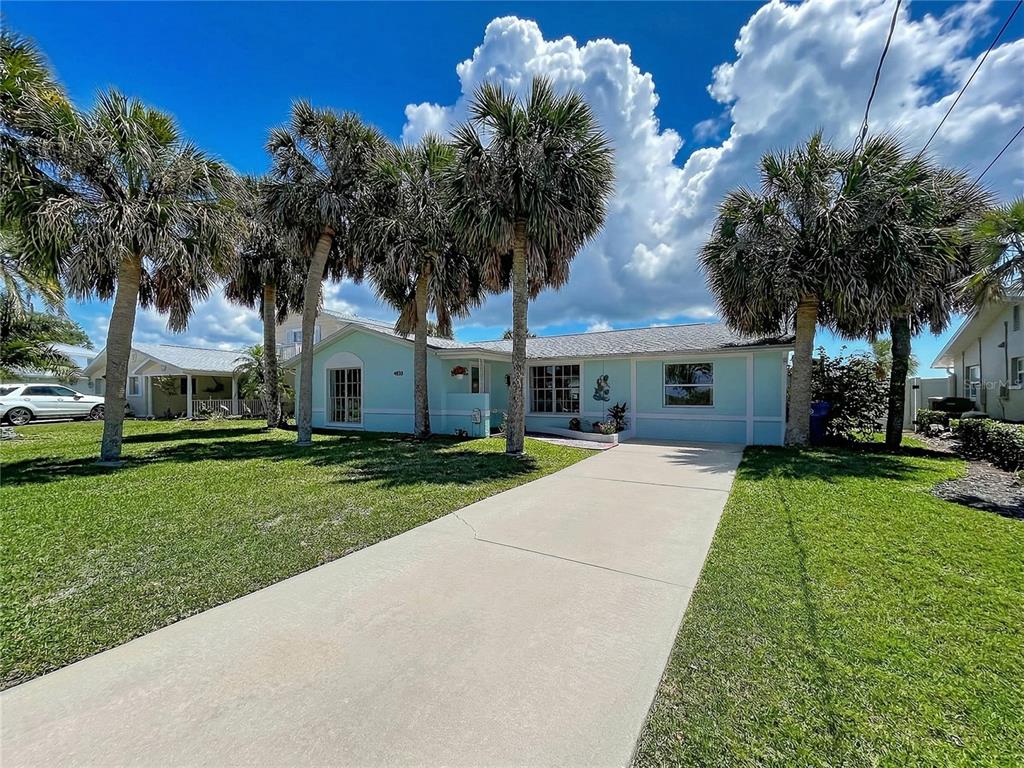 A light blue single-story house with a concrete driveway and several palm trees in front — 4930 BAY PARK DRIVE, PORT RICHEY, FL