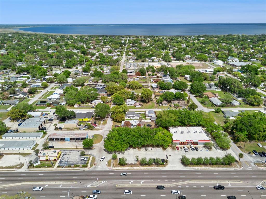 An aerial view shows a commercial area with a large parking lot and surrounding residential neighborhood — 1215 WISCONSIN AVENUE, ST CLOUD, FL