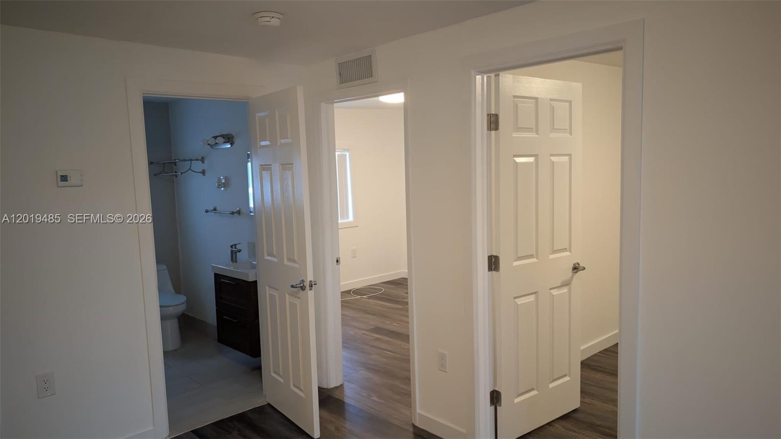 A hallway features three white doors opening into a bathroom and two bedrooms — 76 W 14th St, Hialeah FL 33010, HIALEAH, FL