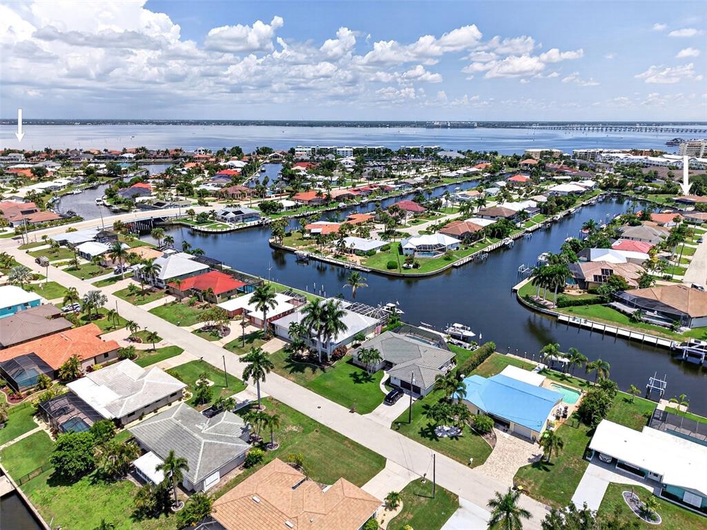 An aerial view shows waterfront houses with pools along canals leading to a large bay — 359 BAL HARBOR BOULEVARD, PUNTA GORDA, FL