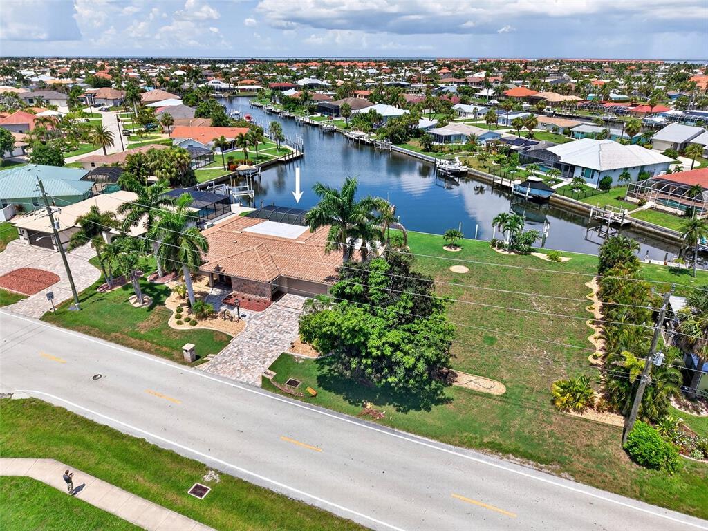 An aerial view shows a waterfront house with a pool cage and a large lawn — 359 BAL HARBOR BOULEVARD, PUNTA GORDA, FL