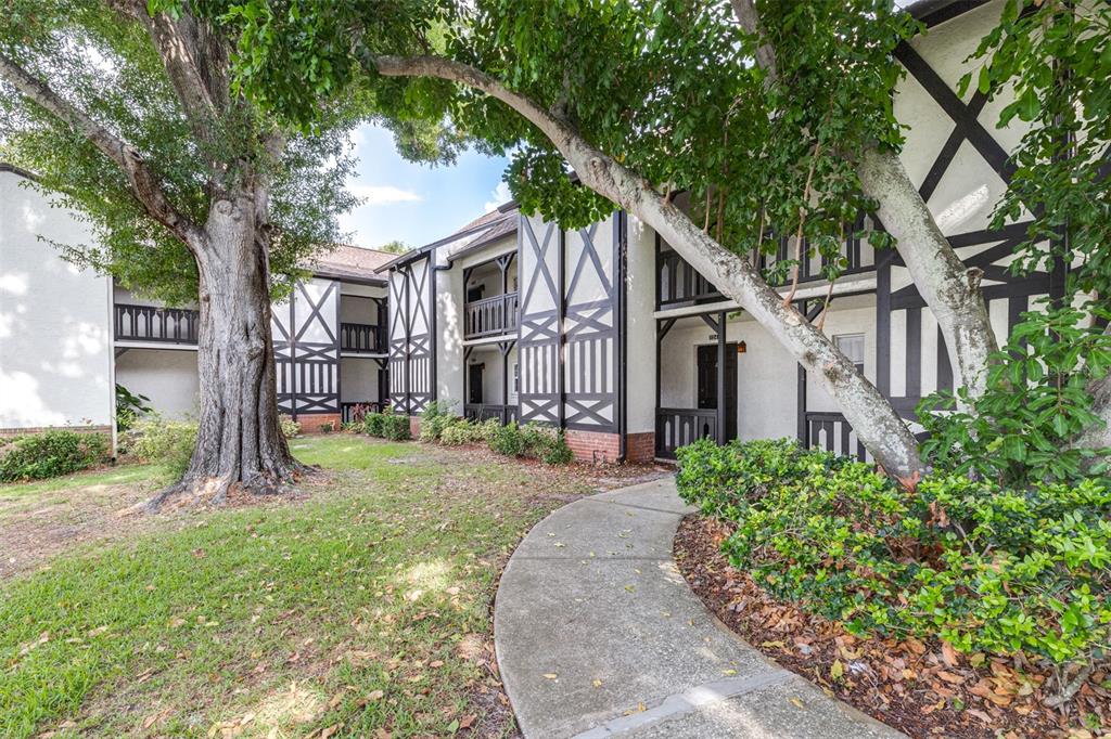 A multi-story apartment building with Tudor-style timber framing and a concrete walkway — 420 N BAYSHORE BOULEVARD UNIT 102, CLEARWATER, FL