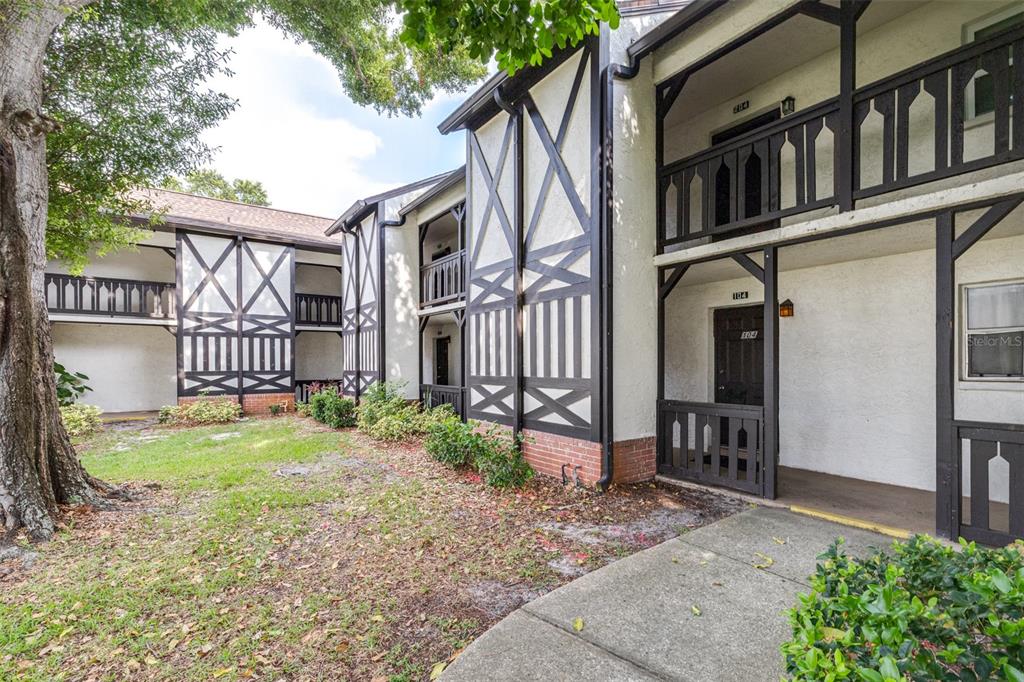 The exterior of a two-story apartment building features Tudor-style timber framing and balcony railings — 420 N BAYSHORE BOULEVARD UNIT 102, CLEARWATER, FL