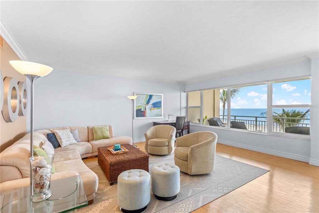 A living room features a beige sectional, two armchairs, and a balcony overlooking the ocean — 603 LONGBOAT CLUB ROAD UNIT 202N, LONGBOAT KEY, FL
