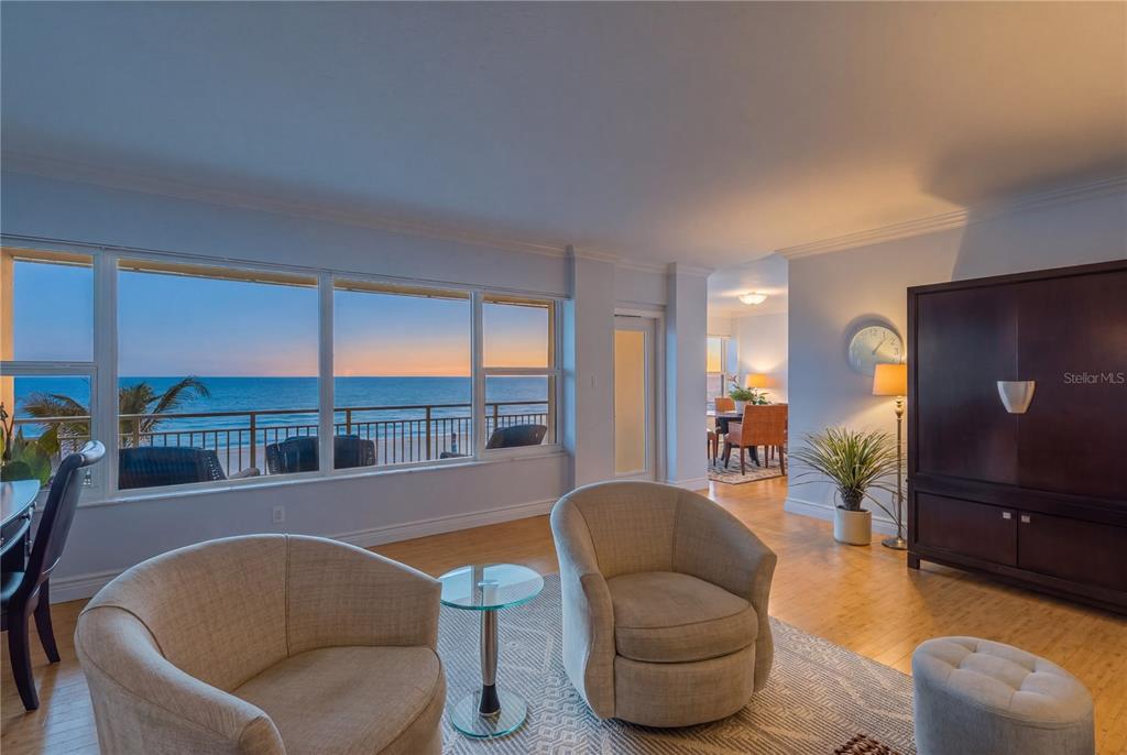 A living room with two armchairs, a glass side table, and a large ocean-view window — 603 LONGBOAT CLUB ROAD UNIT 202N, LONGBOAT KEY, FL