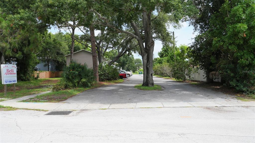 A paved driveway leads to a residential property shaded by large trees — 4015 76TH AVENUE N UNIT 4025, PINELLAS PARK, FL