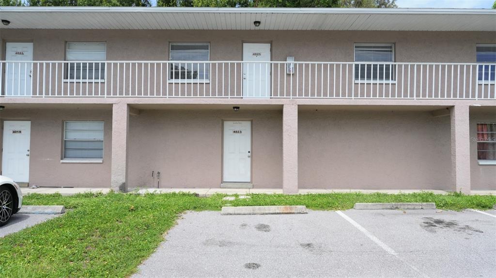 A two-story apartment building exterior features a white balcony railing and several entry doors — 4015 76TH AVENUE N UNIT 4025, PINELLAS PARK, FL