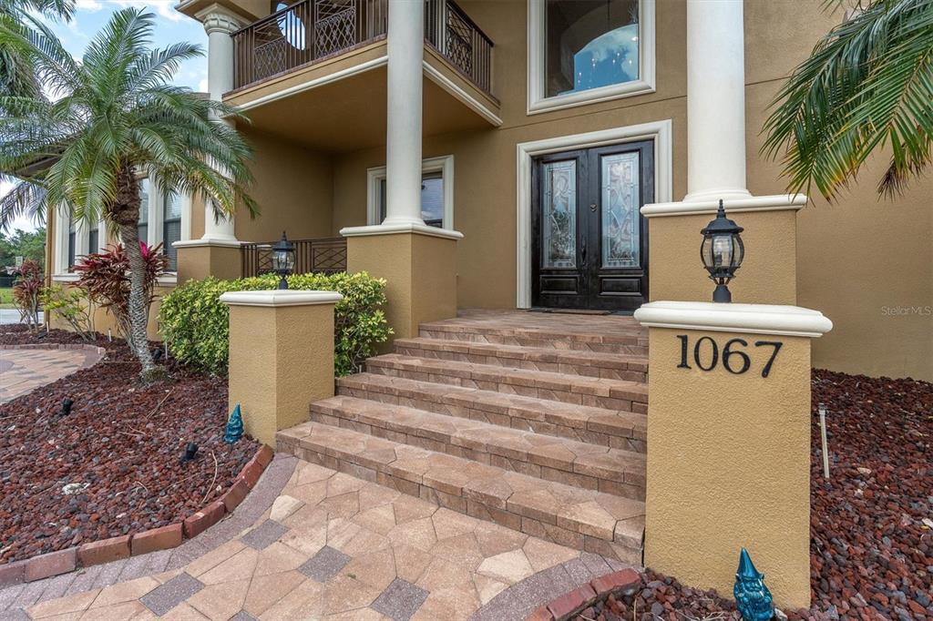 The exterior entrance features stone steps leading to a double front door with glass inserts — 1067 ASHLAND AVENUE, TARPON SPRINGS, FL