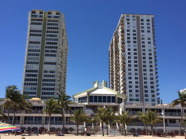 Two tall residential towers stand behind a multi-level building with a beachside patio — 101 Briny Avenue # 707, Pompano Beach FL 33062, POMPANO BEACH, FL