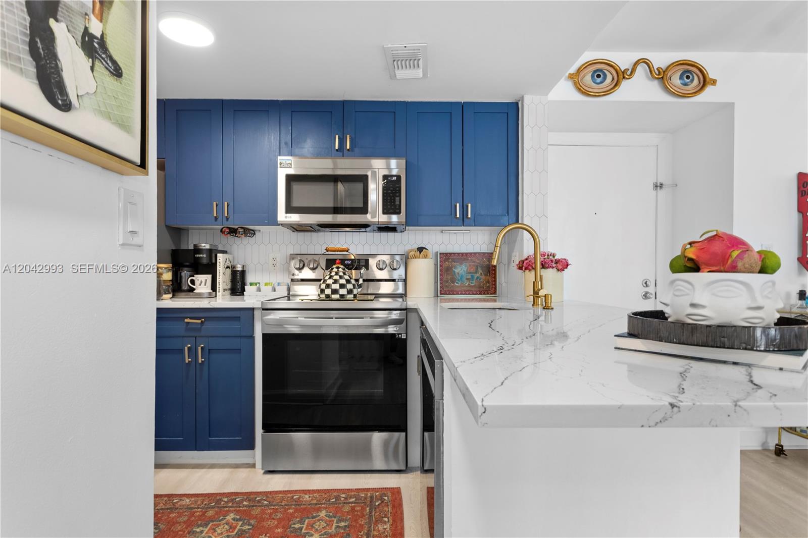 A white fireplace with a mounted television, a floor lamp, and a white armchair — 770 Claughton Island Dr # 1705, Miami FL 33131, MIAMI, FL