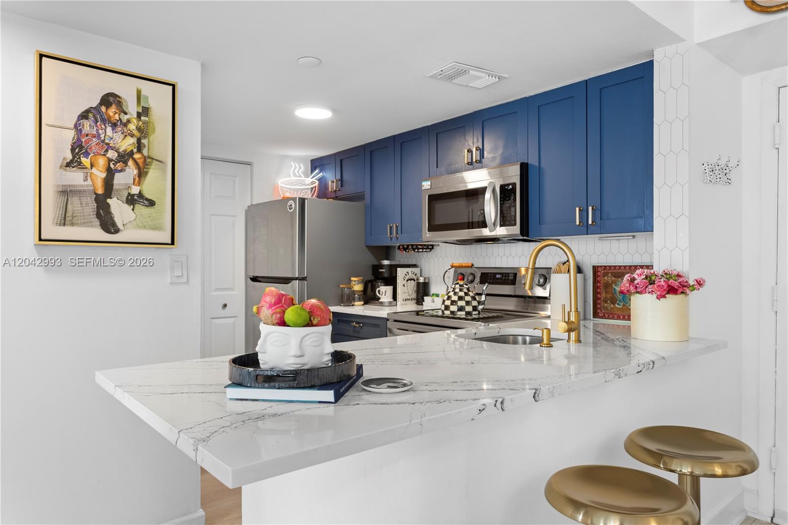 A white kitchen features stainless steel appliances, a marble countertop, and a patterned area rug — 770 Claughton Island Dr # 1705, Miami FL 33131, MIAMI, FL