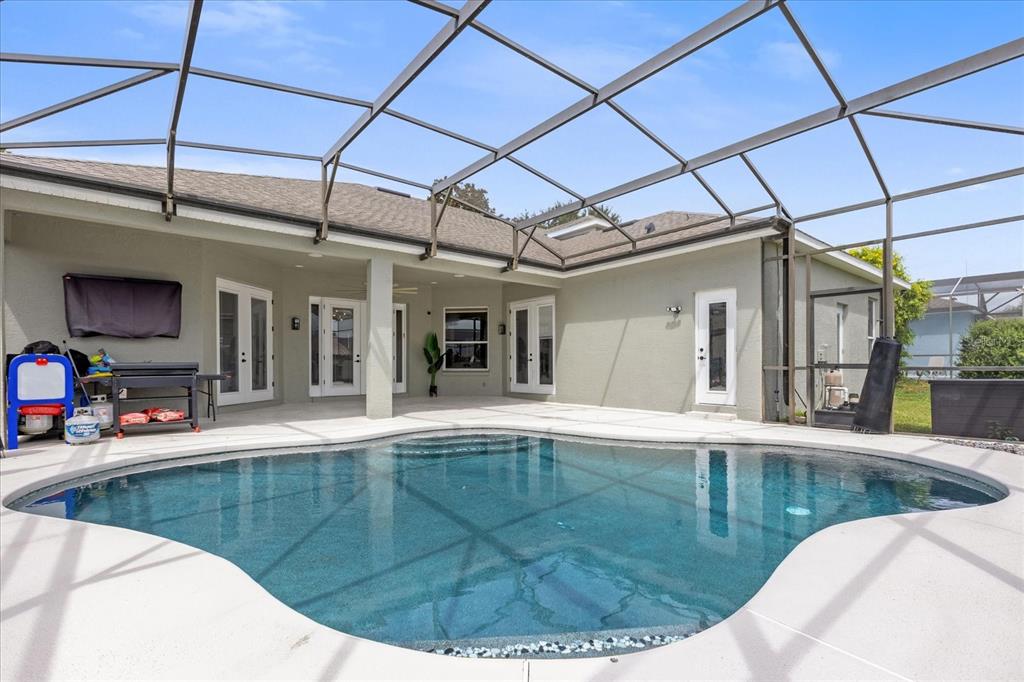 A screened-in patio features a swimming pool and multiple glass doors leading into the house — 10175 COVE LAKE DRIVE, ORLANDO, FL