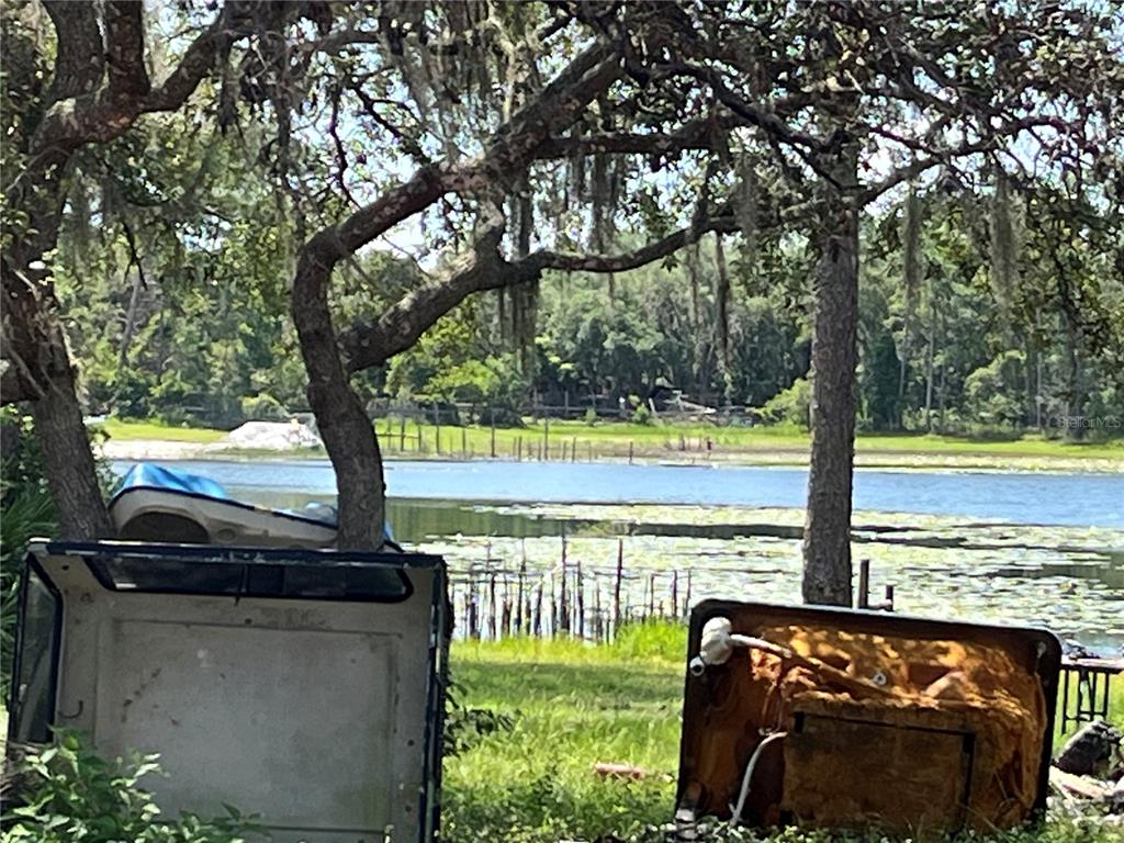 A view of a lake from a grassy yard with two discarded items in foreground — 42334 W LAKE ROAD, DELAND, FL