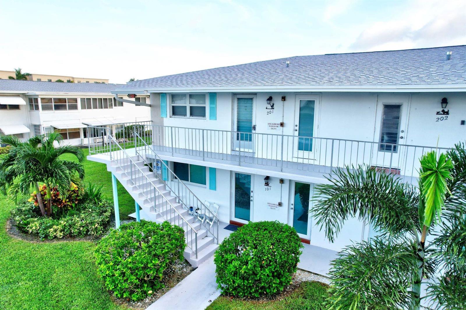 An exterior view of a two-story apartment building with stairs leading to the second floor — 1801 Ocean Drive # 201, Boynton Beach FL 33426, BOYNTON BEACH, FL