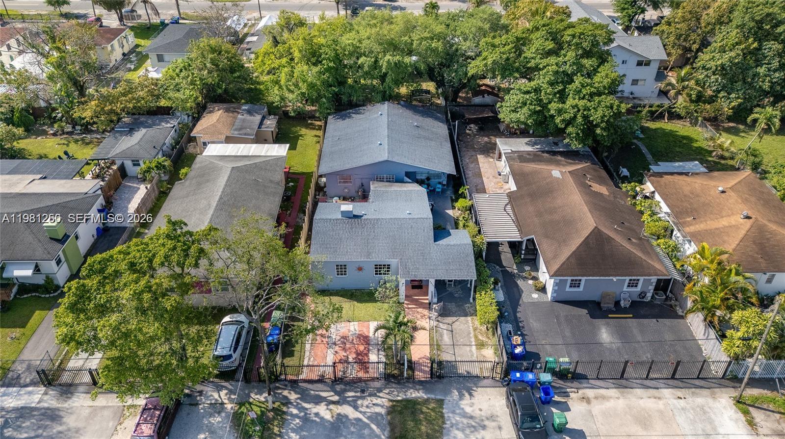 An aerial view shows several residential houses with driveways and trees in a suburban neighborhood — 2610 NW 33rd St, Miami FL 33142, MIAMI, FL