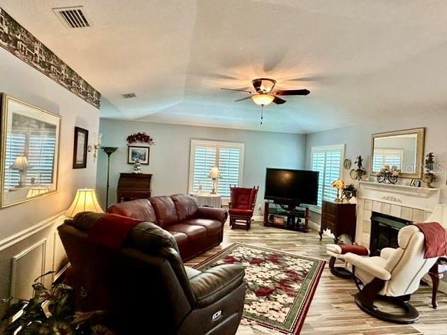 A living room features a vaulted ceiling, a leather sofa, a recliner, and a fireplace — 15116 ROUNDUP DRIVE, TAMPA, FL