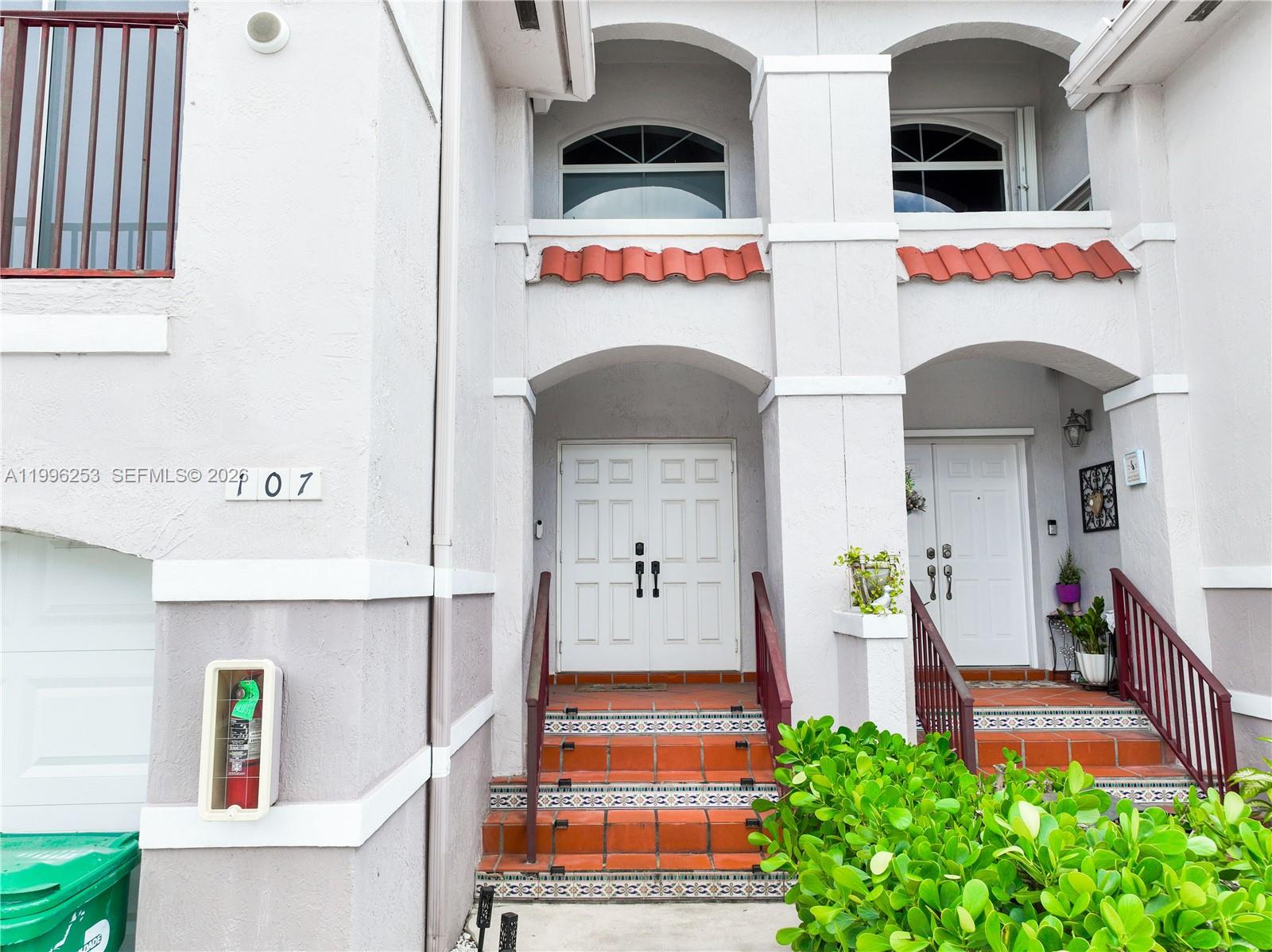 The exterior of a multi-story building features two white double-door entrances with tiled steps — 10101 SW 154th Cir Ct # 107, Miami FL 33196, MIAMI, FL