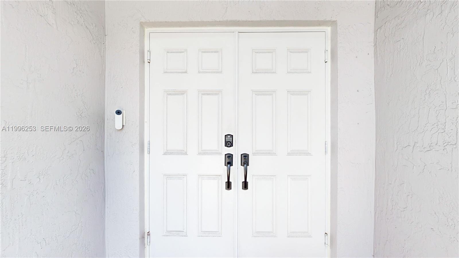 A white double front door features black hardware and a smart doorbell on the wall — 10101 SW 154th Cir Ct # 107, Miami FL 33196, MIAMI, FL